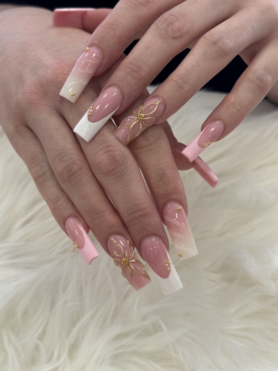 Nude pink builder-gel nails with white French tips and hand-painted gold floral art, done at American Nail Designs