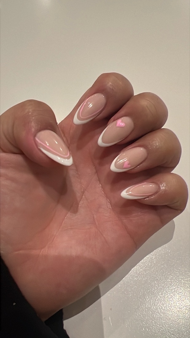 Almond nails with white French tips and small pink heart accents