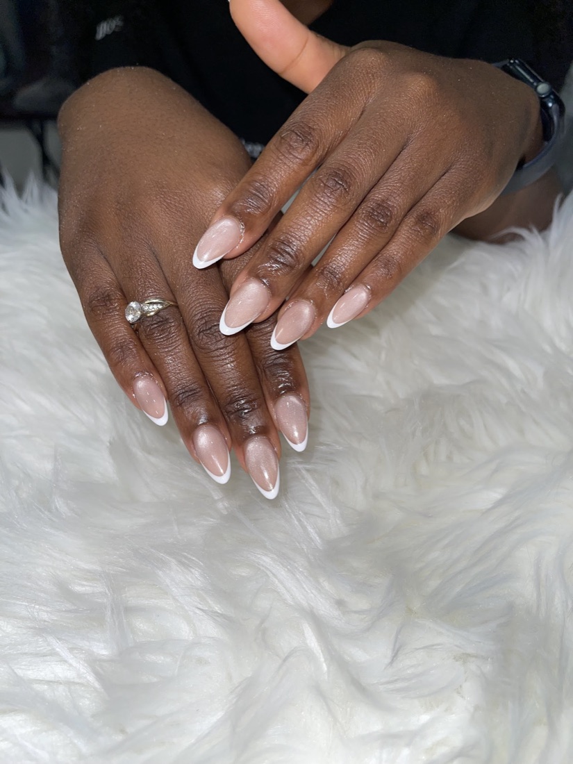 Almond-shape nails with a natural nude base and crisp white French tips
